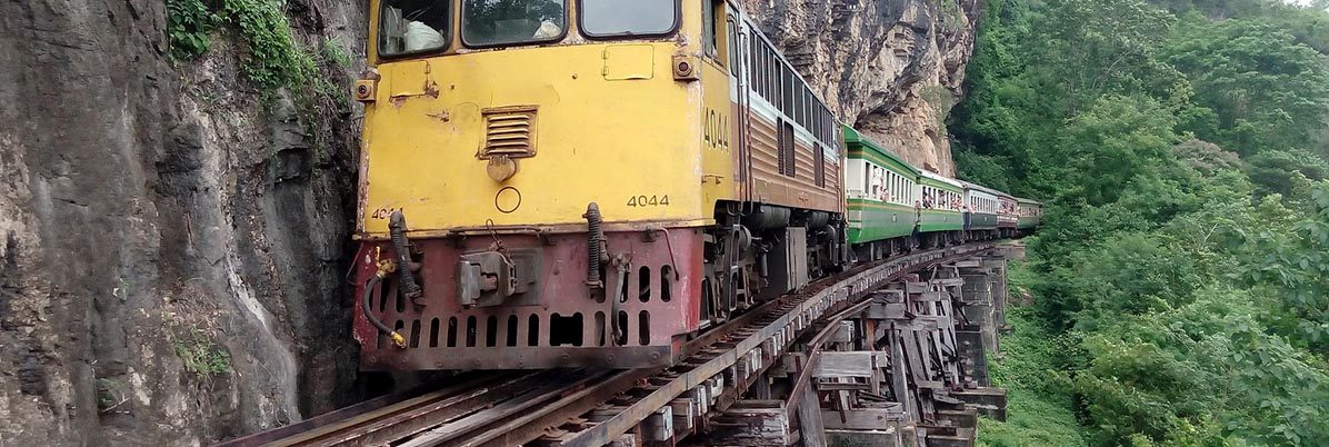 Train on the Wampo Viaduct, running alongside a cliff
