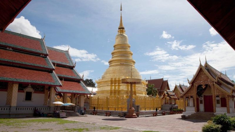 A golden temple in a sunny sky in Lamphun