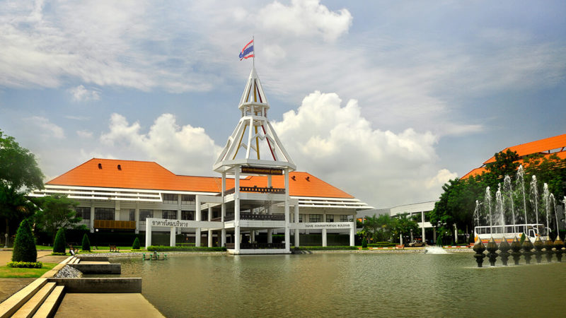 A modern building in Thammasat University with a flag pole